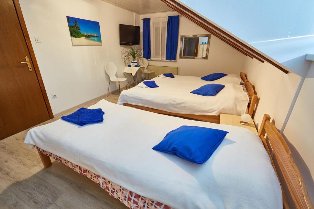 2 camas en una habitación con almohadas azules en Apartma Steles, en Stari Trg pri Ložu