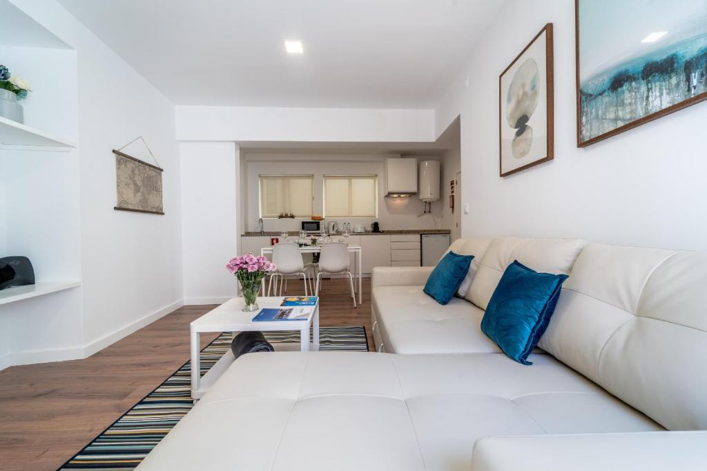 ein Wohnzimmer mit einem weißen Sofa und einem Tisch in der Unterkunft Praça Velha I in Braga