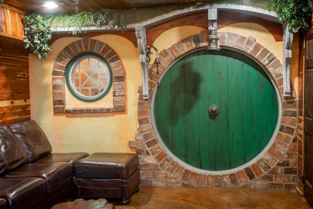 a living room with a green door and a couch at The Hobbit House, Fantasy comes Home! in Russellville