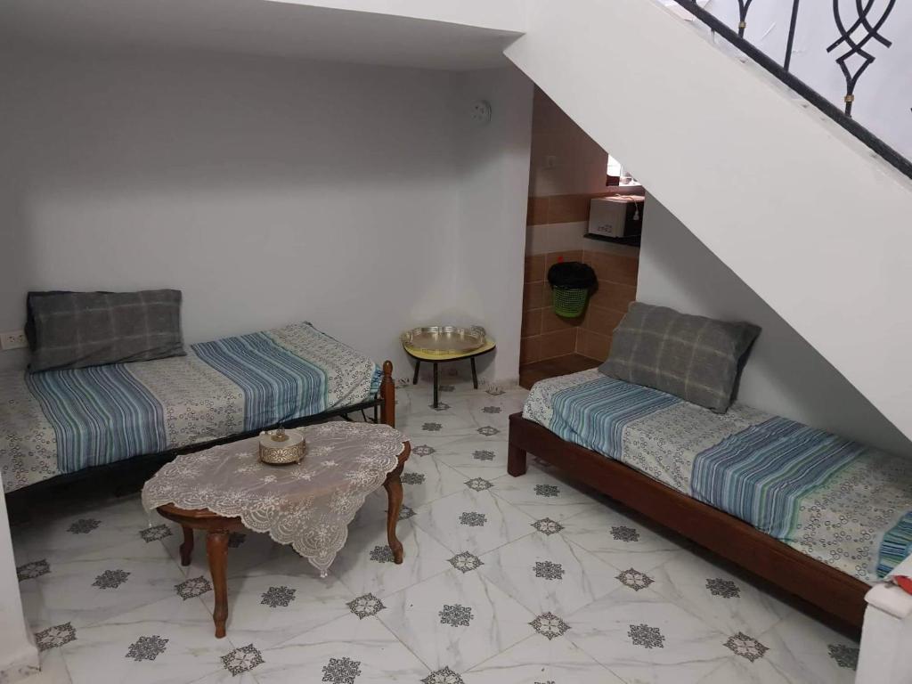 um quarto no sótão com 2 camas e uma mesa em Cirta duplexe em Constantina