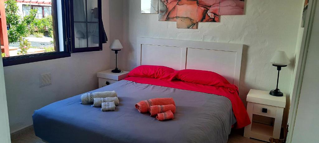 a bedroom with a bed with two pillows on it at Sun beach Caleta 24 in Caleta De Fuste