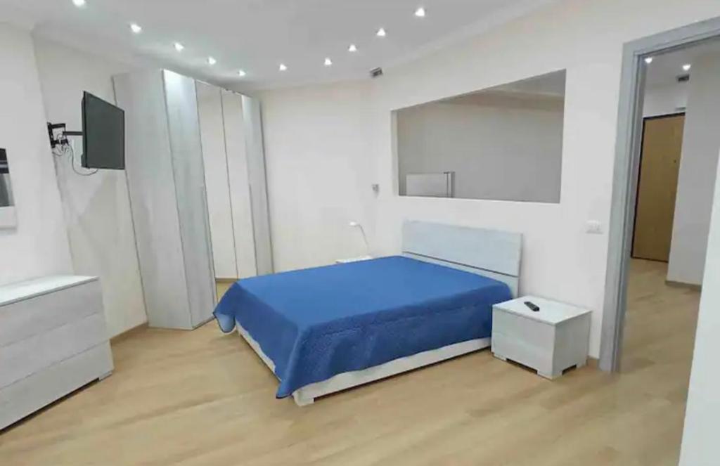 1 dormitorio con 1 cama azul y TV en Roomors Of Naples - Business District 2, en Nápoles