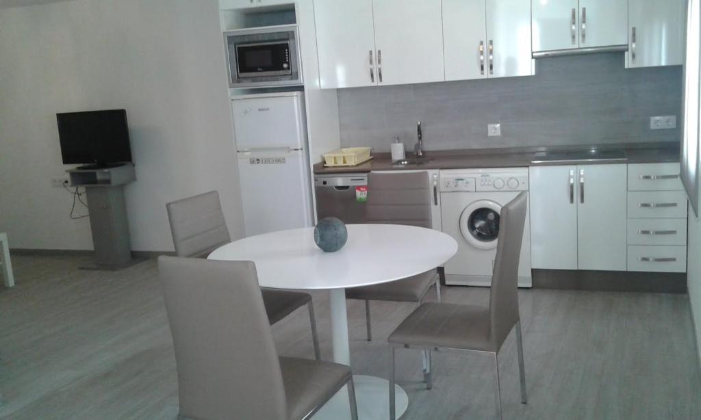a kitchen with a white table and chairs and a sink at CASA BALUARTE in Conil de la Frontera