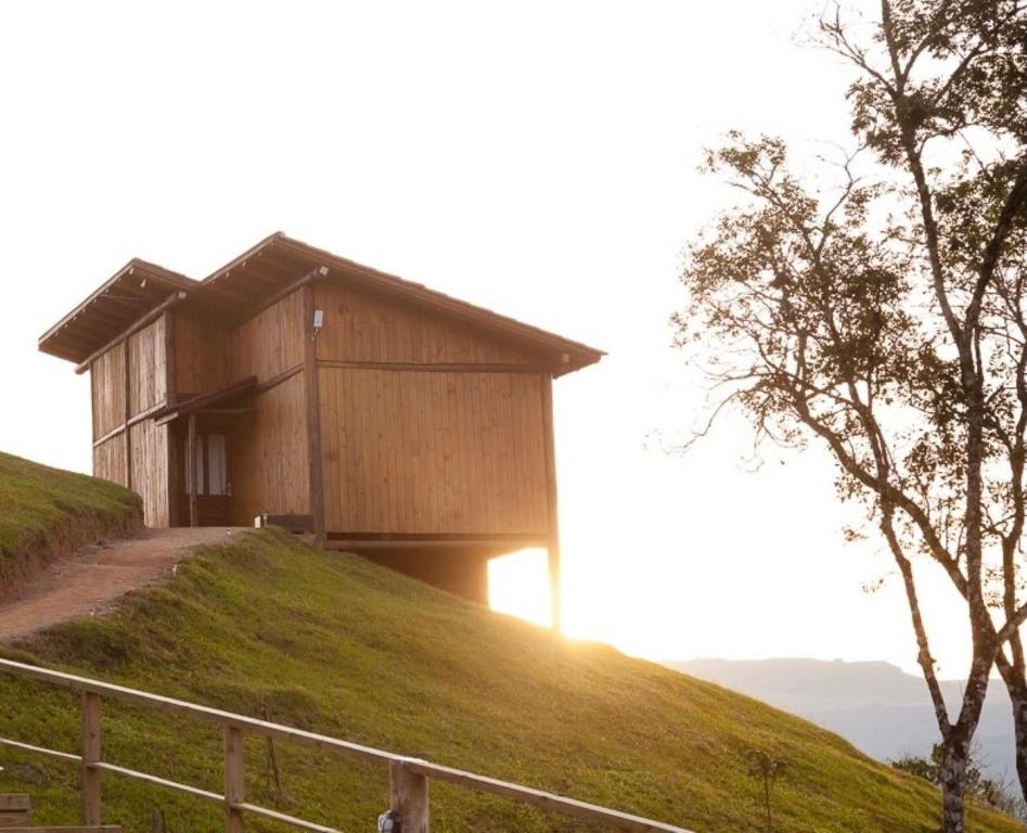 a house on top of a grassy hill at Cabanas Recanto do Rancho - Rancho Queimado in Rancho Queimado