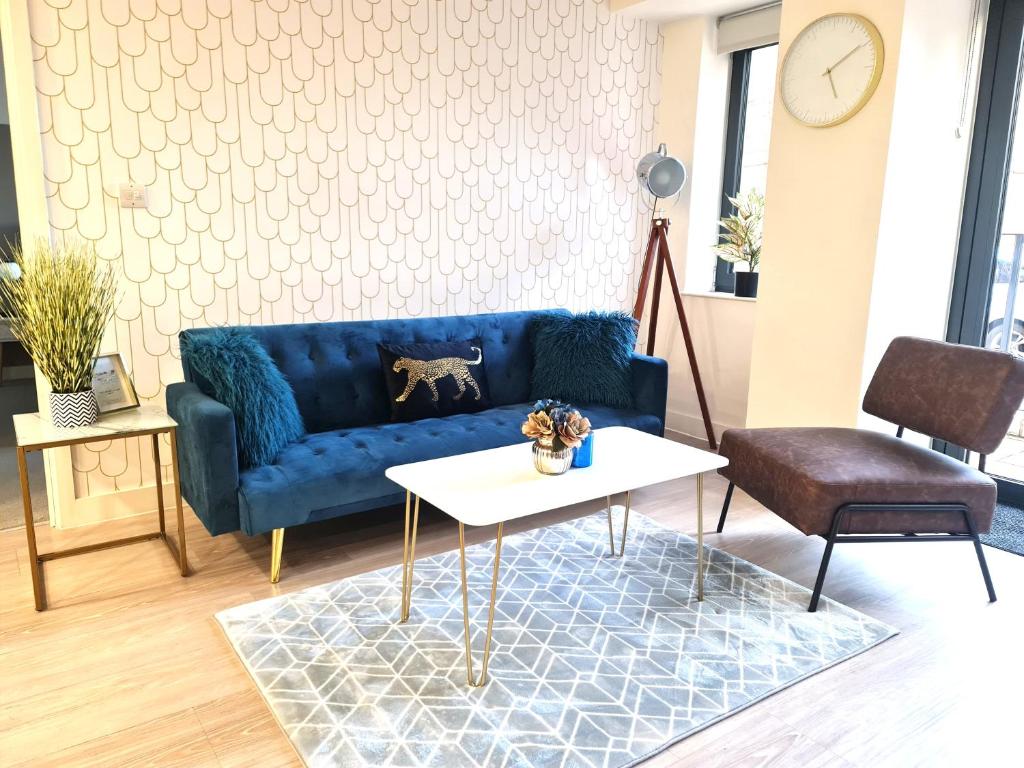 ベッドフォードにあるBright 2BR in Bedford, Parking, Free WiFi, Gym & Cinema roomの青いソファとテーブルのあるリビングルーム