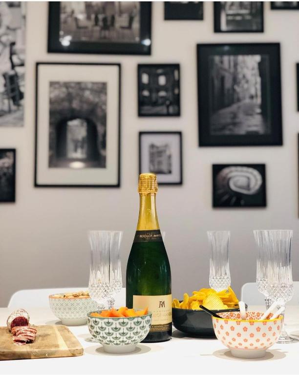 a bottle of wine sitting on a table with bowls of food at La Maison du Quai Triplex de charme 4 étoiles en hyper centre avec SPA in Landerneau
