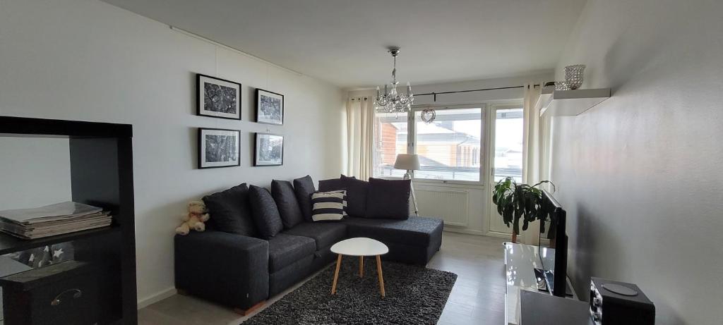 a living room with a black couch and a table at City Apartment Snellmaninkatu 22 A in Kuopio