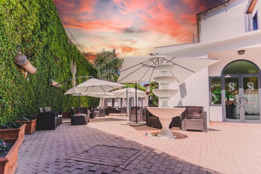 un patio con ombrelloni accanto a un edificio di CANELLA HOTEL a Roma
