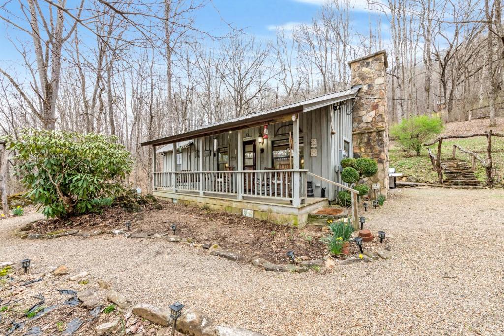 uma pequena casa com um alpendre e um quintal em Hidden Creek Cabin em Franklin