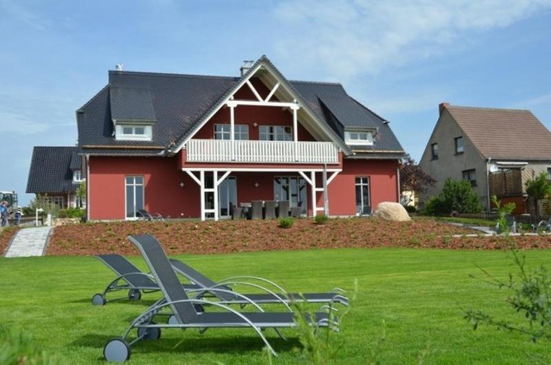 ein Haus mit zwei Gartenstühlen davor in der Unterkunft Landhaus Hagenblick - Apt. 02 in Alt Reddevitz