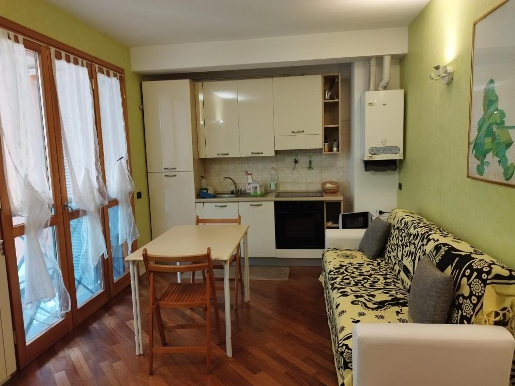 uma sala de estar com um sofá, uma mesa e uma cozinha em Monolocale Politecnico Bovisa em Milão