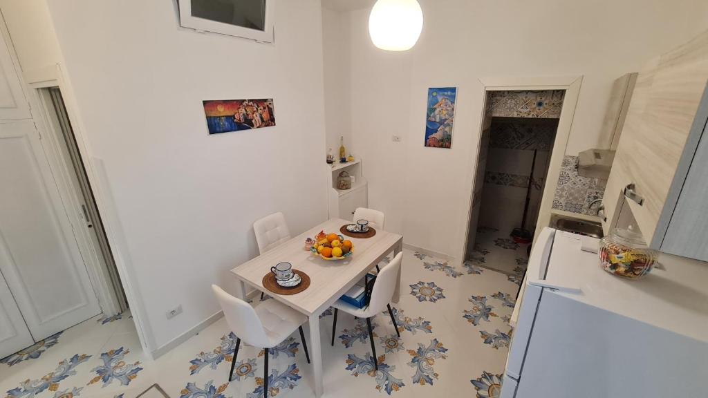 a kitchen with a white table and chairs and a white refrigerator at Casa Piccina in Praiano