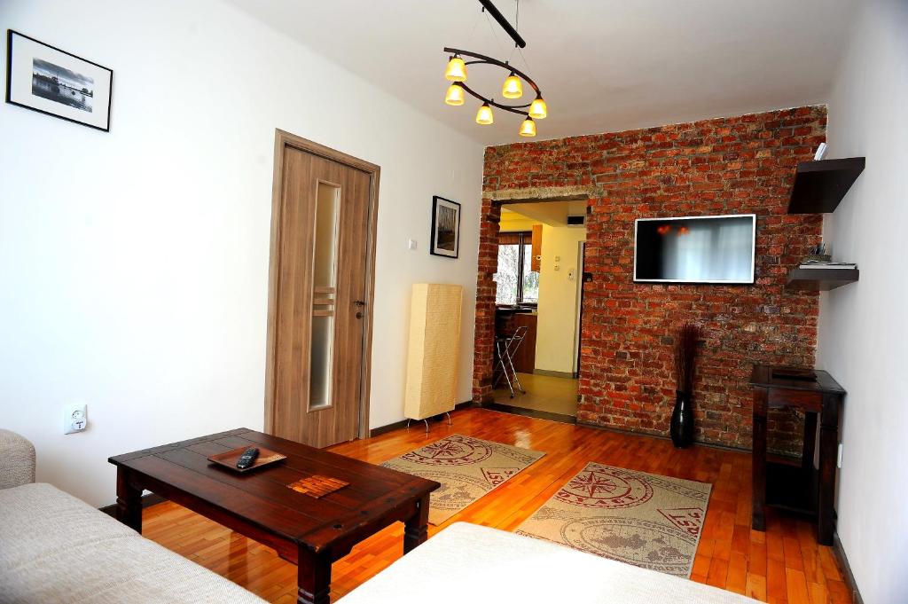 a living room with a couch and a brick wall at Apartament Downtown Cluj-Napoca in Cluj-Napoca