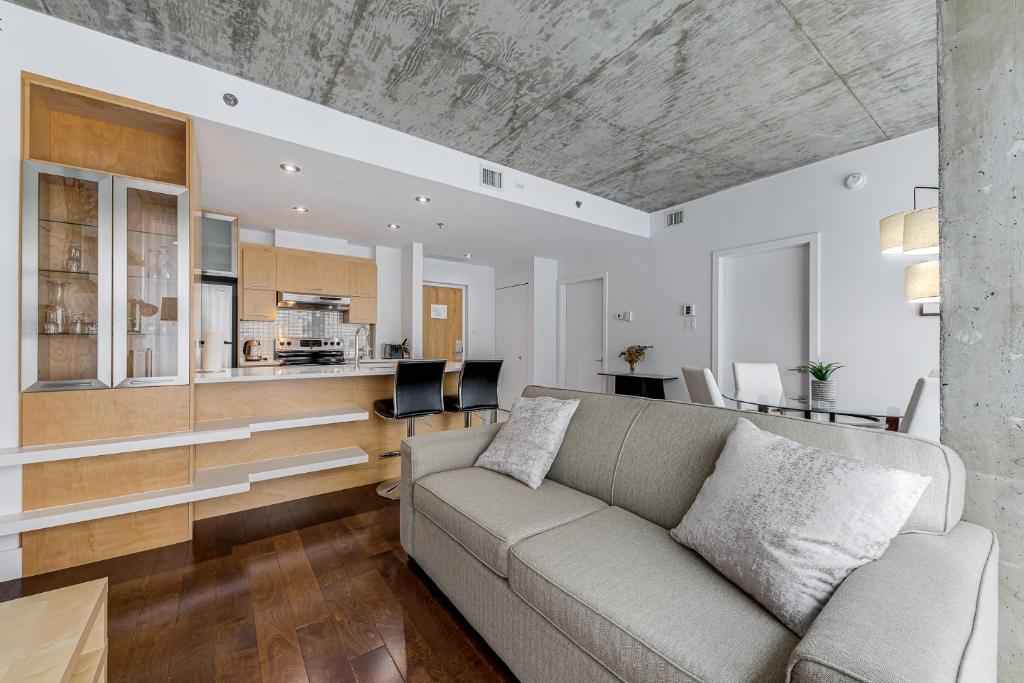 uma sala de estar com um sofá e uma cozinha em Les Immeubles Charlevoix - Le 760207 em Cidade de Quebec
