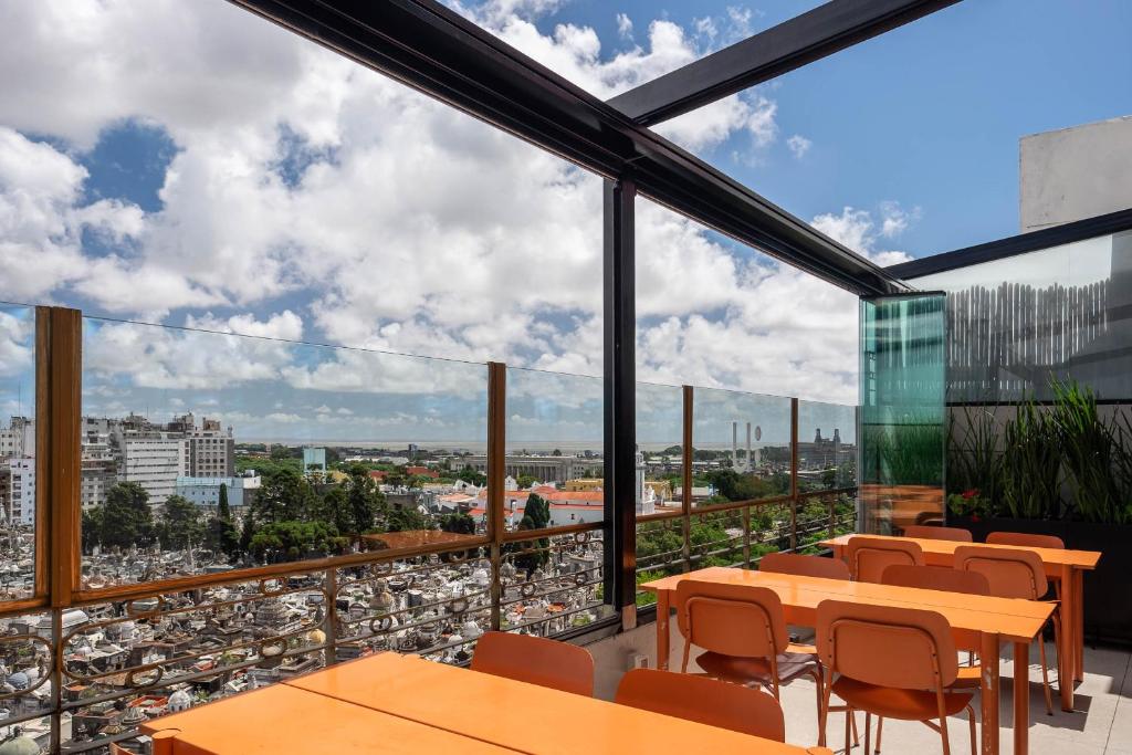ブエノスアイレスにあるUrban Suites Recoleta Boutique Hotelのテーブルと椅子付きのレストランのバルコニーから景色を望めます。