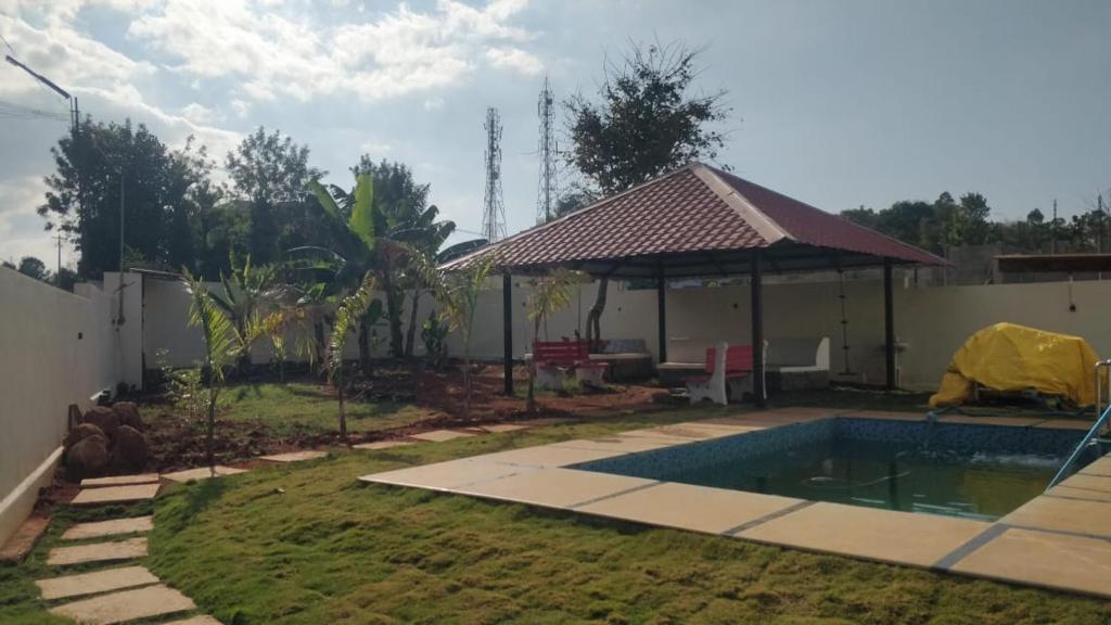 un patio trasero con piscina y pabellón en NanDha Illam- The Courtyard Heritage HomeStay Yelagiri Hills, en Yelagiri
