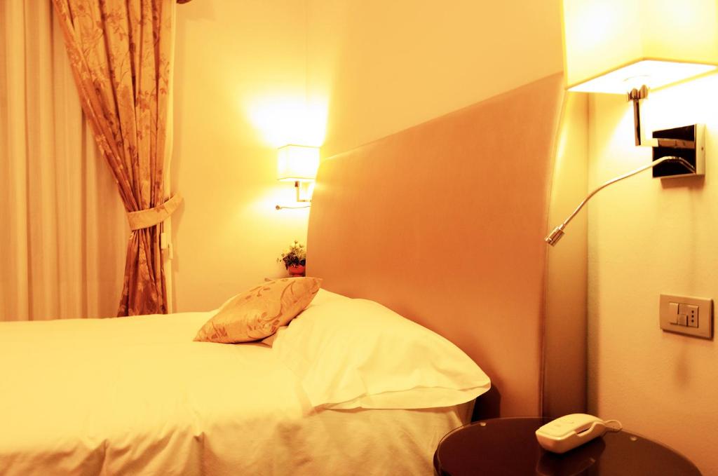 Postel nebo postele na pokoji v ubytování Sangallo Hotel