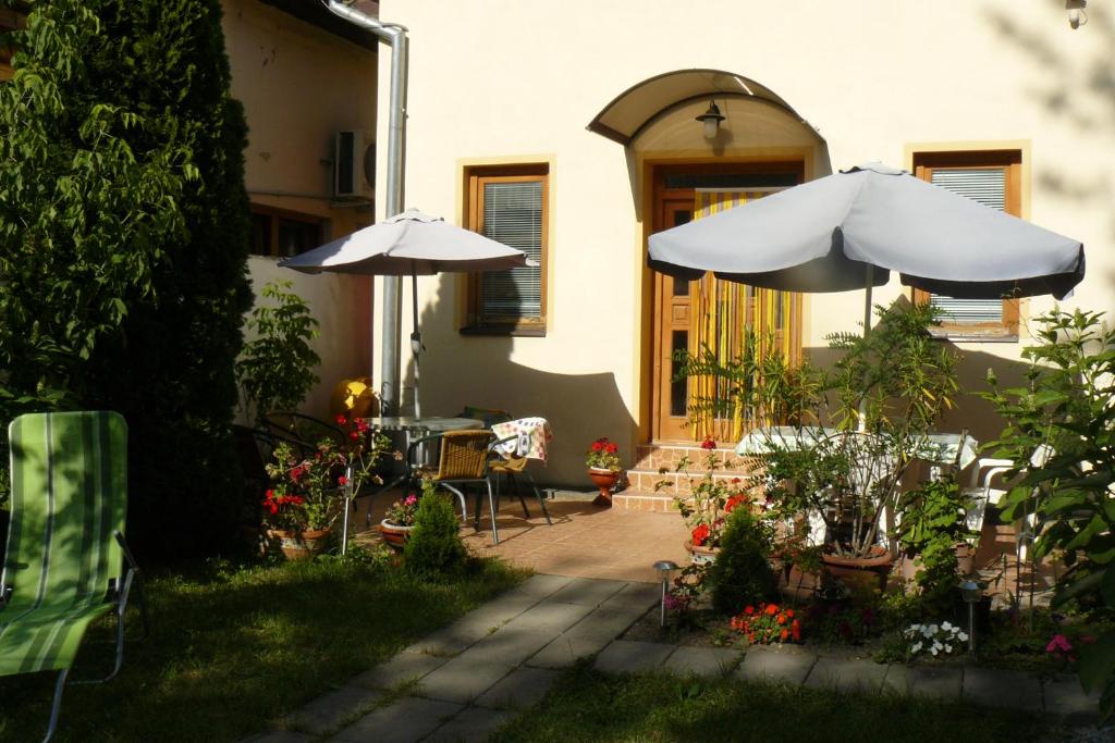 a patio with two umbrellas and a table and chairs at Penzion Rose in Štúrovo