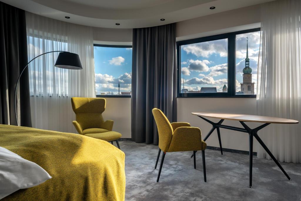 ein Hotelzimmer mit einem Bett, einem Tisch und Stühlen in der Unterkunft Hotel Esplanade Dortmund in Dortmund