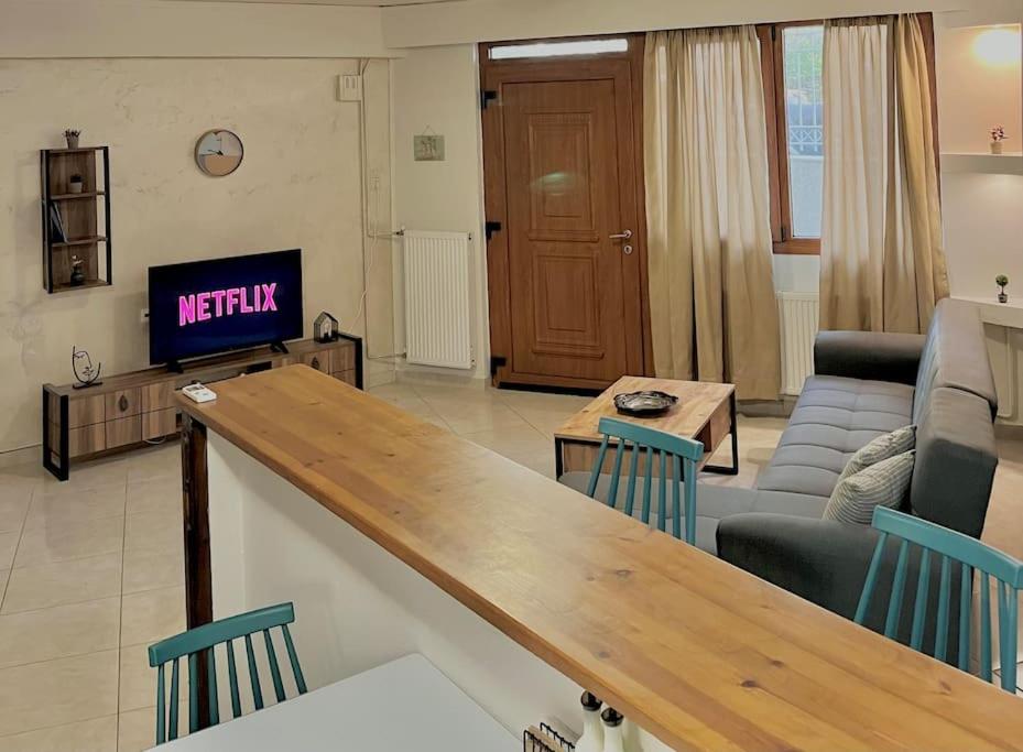 salon z kanapą i telewizorem w obiekcie YOU Home apartment w Heraklionie