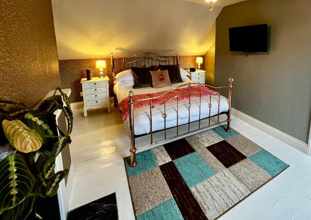 a bedroom with a bed and a tv on the wall at Miller of Mansfield in Goring