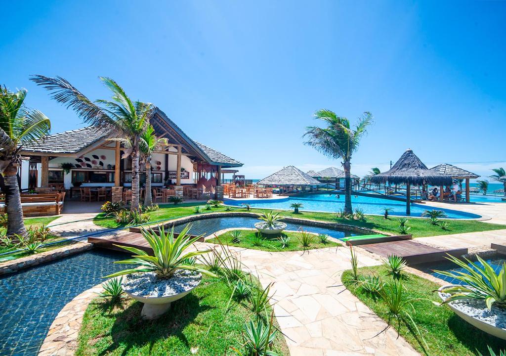 um resort com piscina e palmeiras em The Coral Beach Resort by Atlantica em Trairi