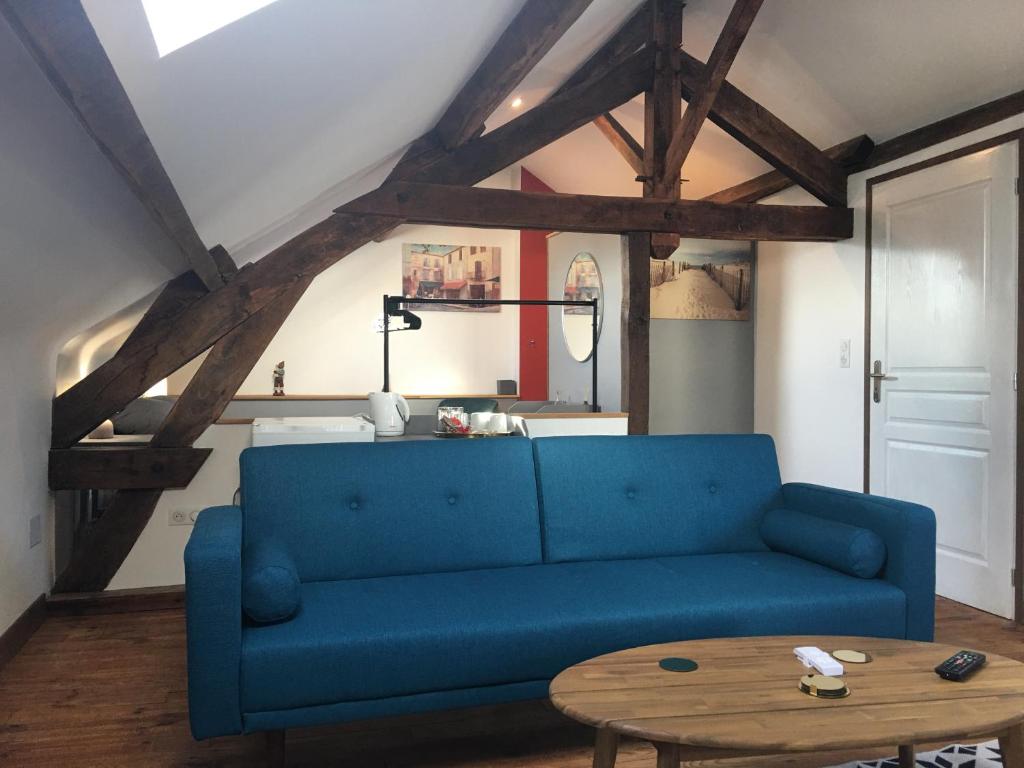 um sofá azul numa sala de estar com uma mesa em La Mirabelle em Saint-Pierre-de-Fursac