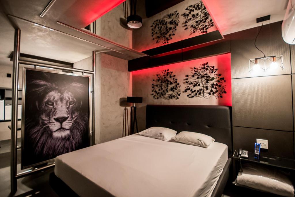 een slaapkamer met een bed met een foto van een leeuw bij Opium Motel (Adult Only) in Sao Paulo
