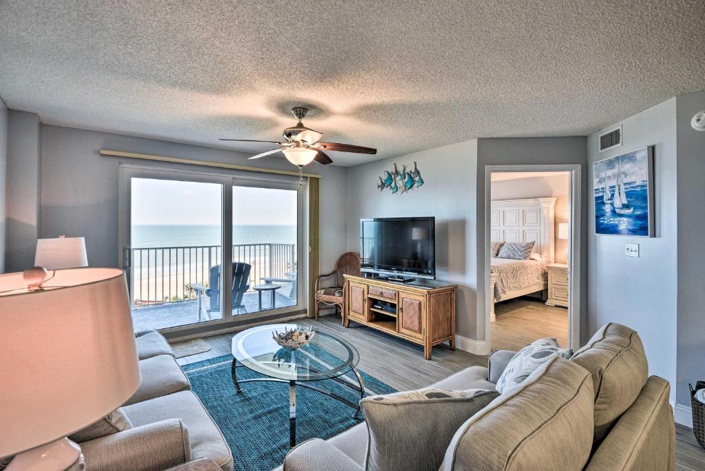 a living room with a couch and a tv at Oceanfront Condo Rental Near Daytona Speedway in Ormond Beach