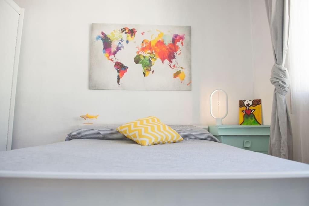 1 dormitorio con 1 cama con una pintura en la pared en Apartamento acogedor en pleno corazón de Urdaibai, en Guernica y Luno