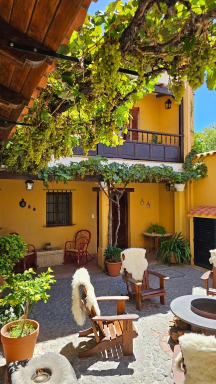 a patio with chairs and tables and a building at Villa Vicuña Wine & Boutique Hotel in Cafayate