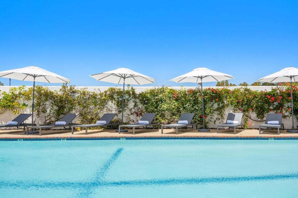 a swimming pool with chairs and umbrellas at Casablanca Inn in San Clemente