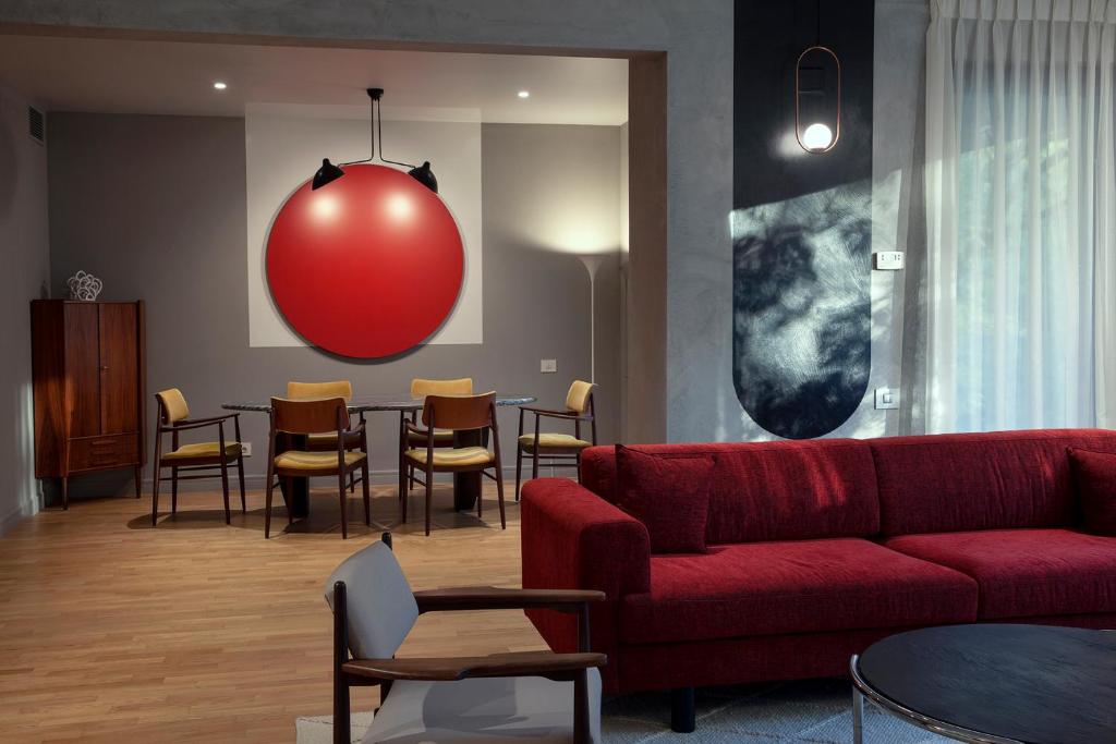 uma sala de estar com um sofá vermelho e uma mesa com cadeiras em Room12 House em Bucareste