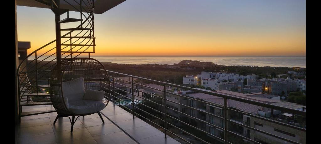 balkon z krzesłem i widokiem na miasto w obiekcie Casa Sola Penthouse w mieście Cabo San Lucas