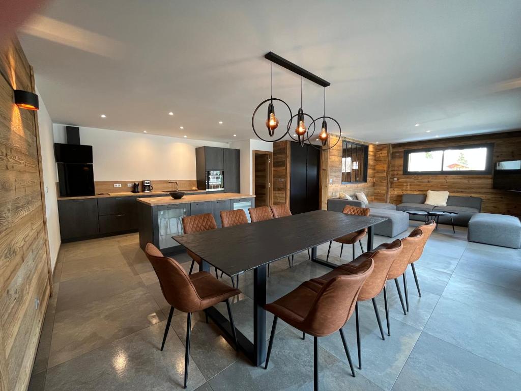 a dining room and living room with a table and chairs at Appartement les Clochettes 1 - Pied des pistes in Les Deux Alpes