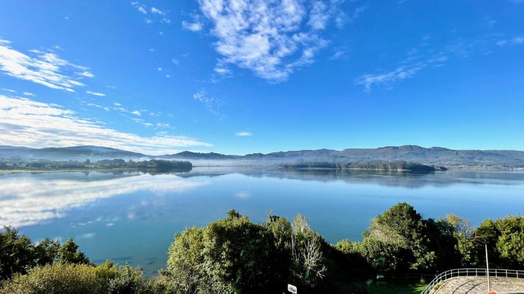 vistas a un lago con montañas en el fondo en The Cliffs - Ortigueira Kalmak, en Santa Marta de Ortigueira