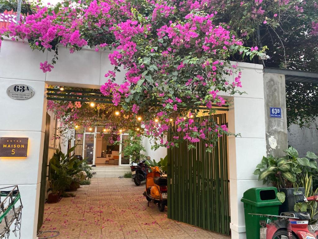 un bâtiment avec des fleurs roses suspendues à un portail dans l'établissement Notre Maison 5 Saigon close Walking street in Thao Dien D2, à Hô-Chi-Minh-Ville