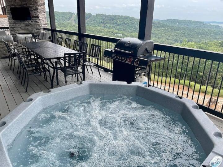 a hot tub on a deck with a grill at Modern Rustic in Branson