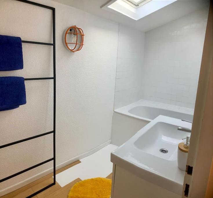 a white bathroom with a sink and a mirror at Charmant Appartement Pop - Arty in Thonon-les-Bains