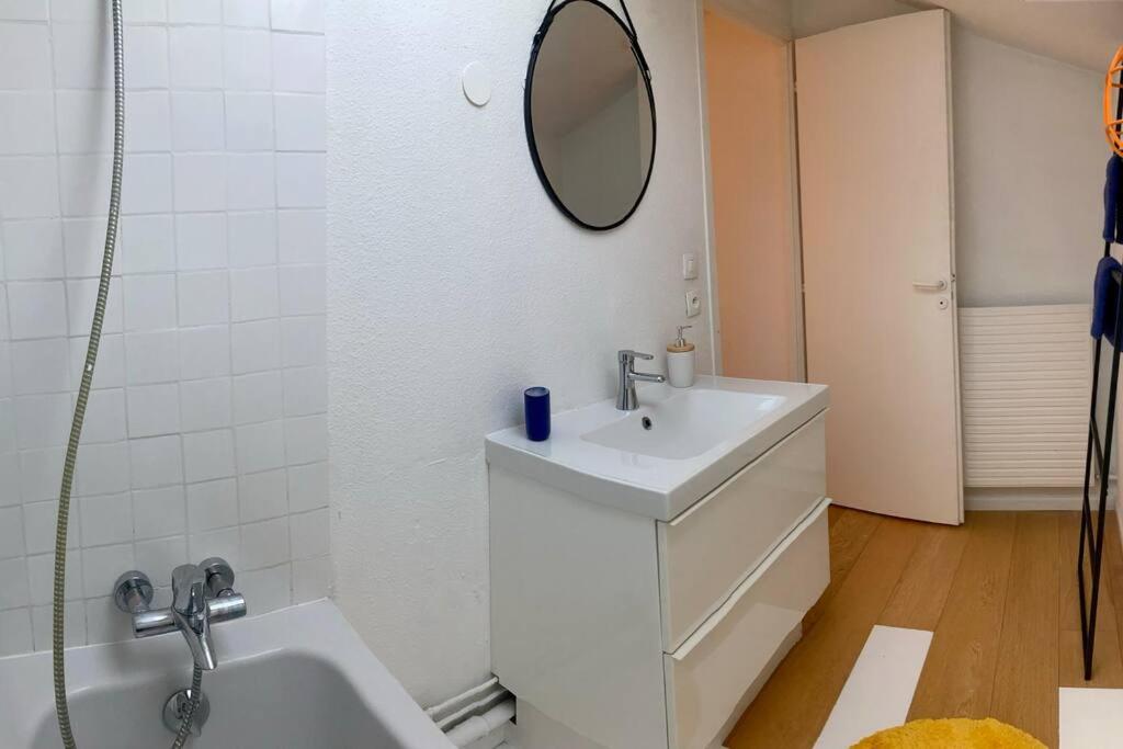 a white bathroom with a sink and a mirror at Charmant Appartement Pop - Arty in Thonon-les-Bains