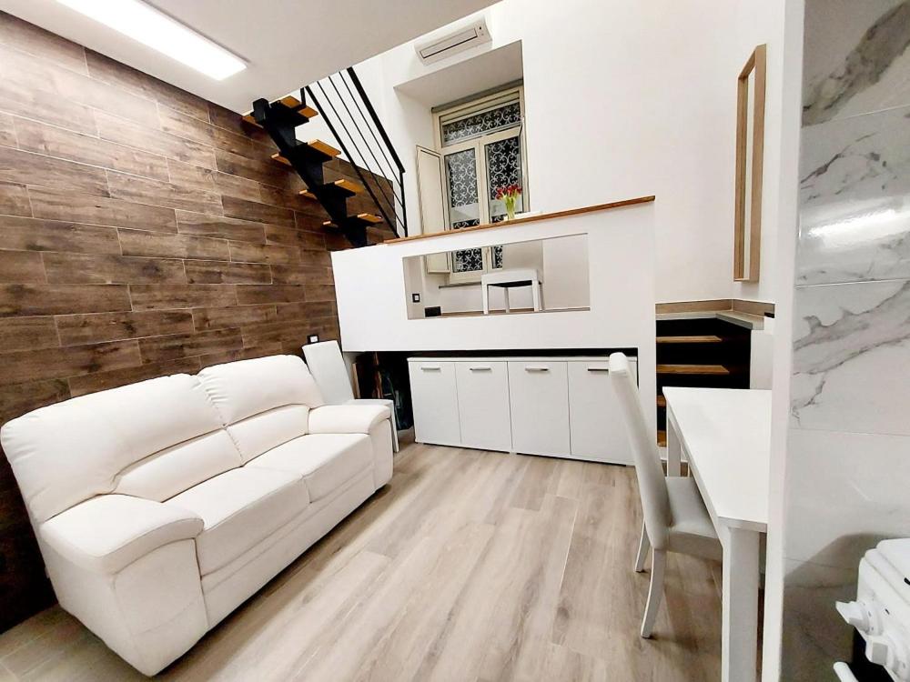 een woonkamer met een witte bank en een tafel bij Mi casa es tu casa in Napels
