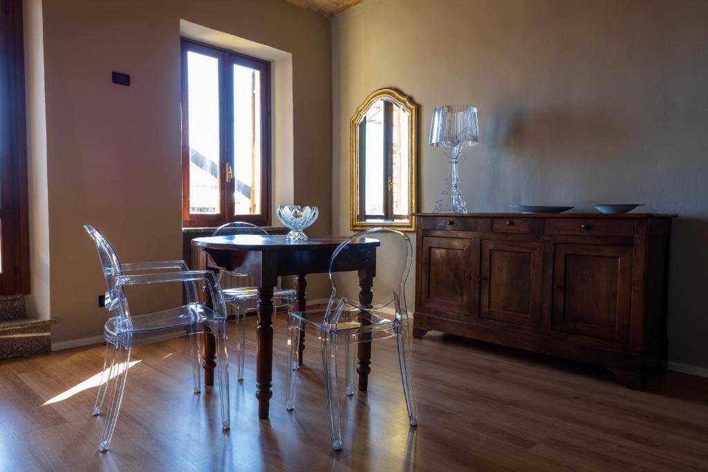 una sala da pranzo con tavolo, sedie e specchio di Alla Torre - nel cuore del Borgo storico a Castagnole Lanze