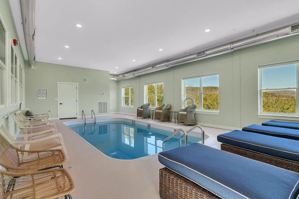 a swimming pool in a house with chairs and a swimming pool at A Wave From It All in Hollister