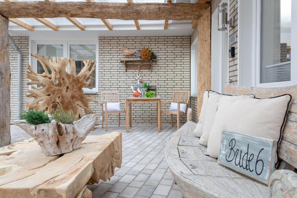 d'une terrasse avec un banc en bois et une table. dans l'établissement Die-Deichbude-1-Bude-6, à Büsum