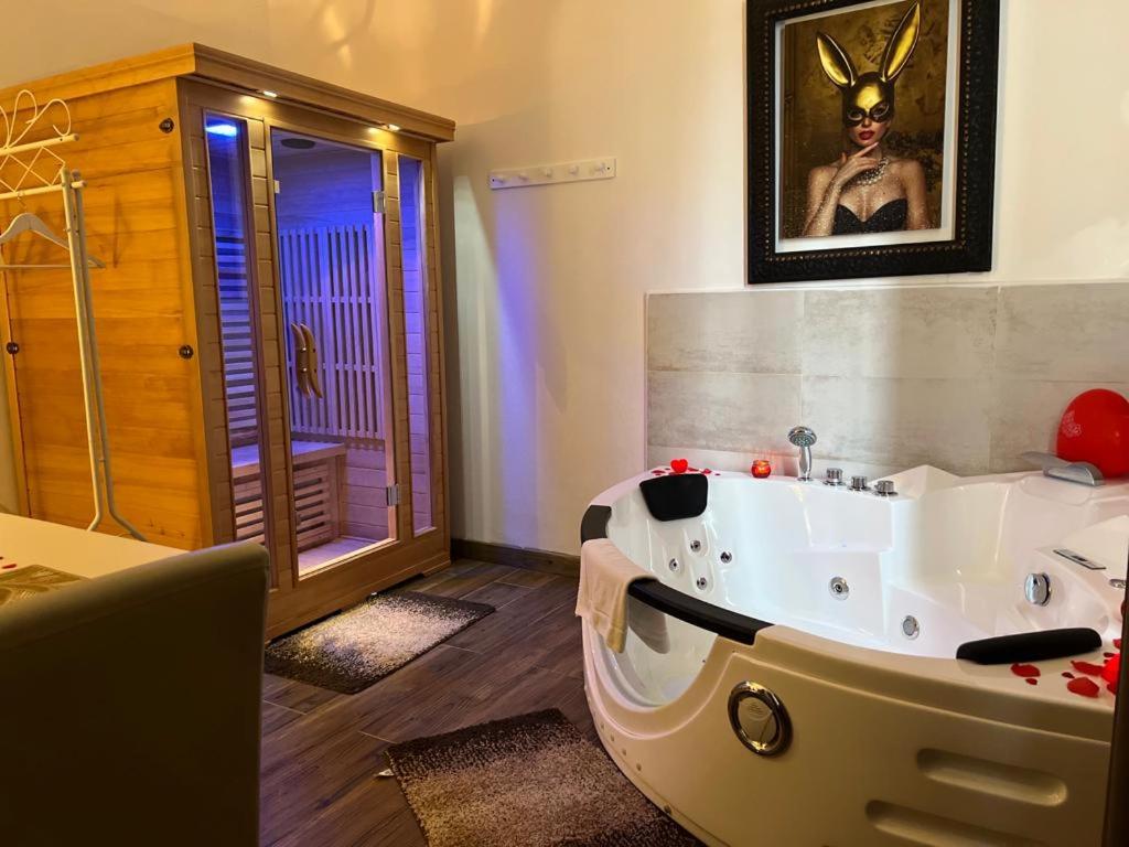a bathroom with a large white bath tub in a room at Notte Rosa Suites & Relax in Fornovo di Taro