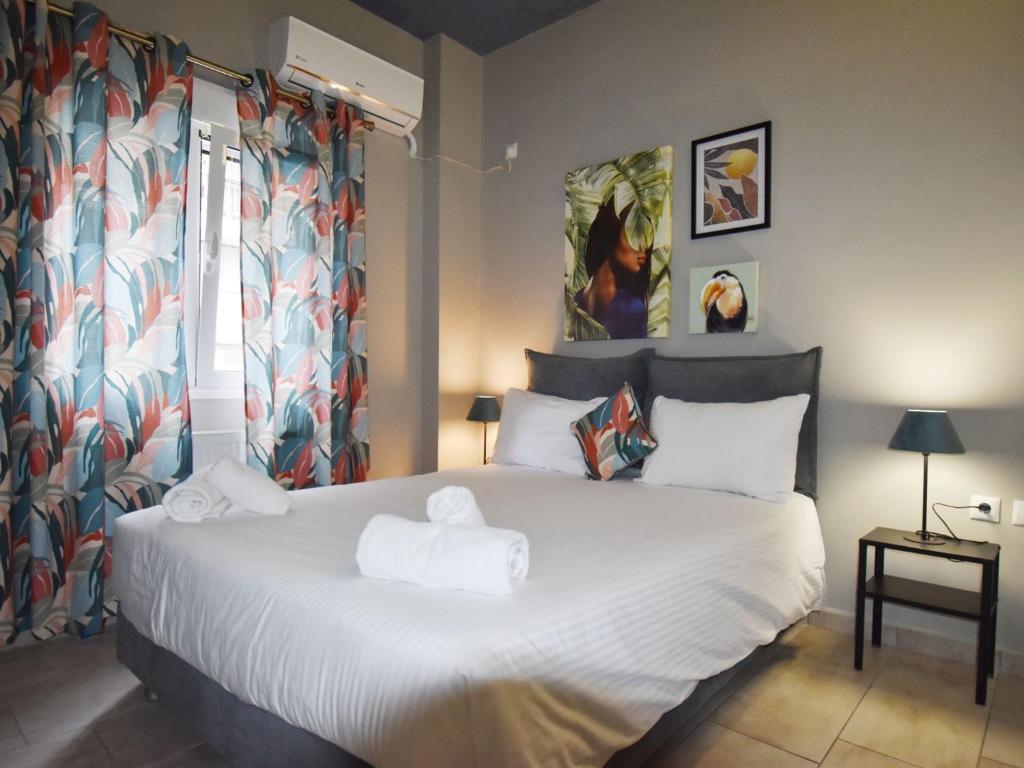 a bedroom with a large white bed with towels on it at Petite Apartment in Athens
