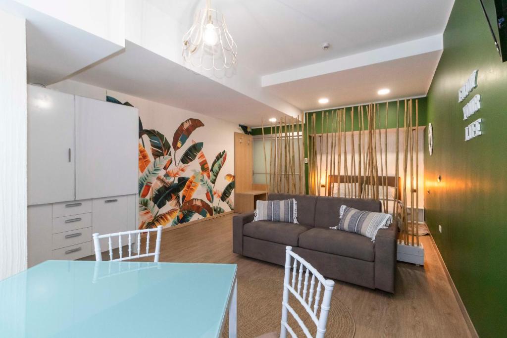 una sala de estar con un sofá y una mesa en Enjoy Room- Appartamento con parcheggio GRATUITO e COLAZIONE DELIZIOSA !, en Turín