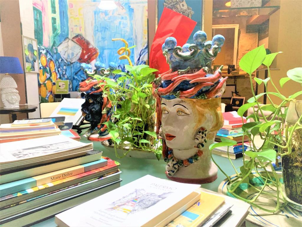 a vase sitting on a table with books and plants at B&B Domus Dei Cocchieri in Palermo