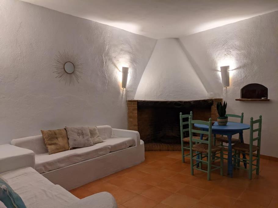 uma sala de estar com um sofá e uma mesa com cadeiras em Casa rural frente al mar La Toscana em Les Cases d'Alcanar