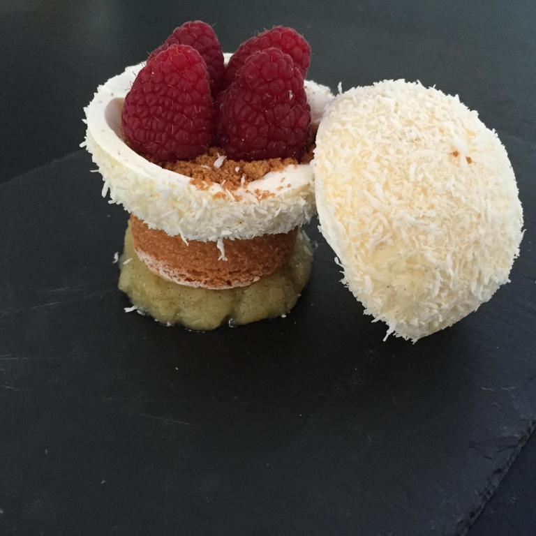 a cake with two raspberries on top of it at Hôtel Restaurant & Spa Plaisir in Le Bois-Plage-en-Ré